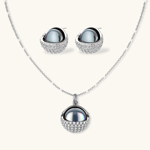White gold plated spherical jewelry set with zirconia crystal pavé and dark lustrous centers on neutral background.